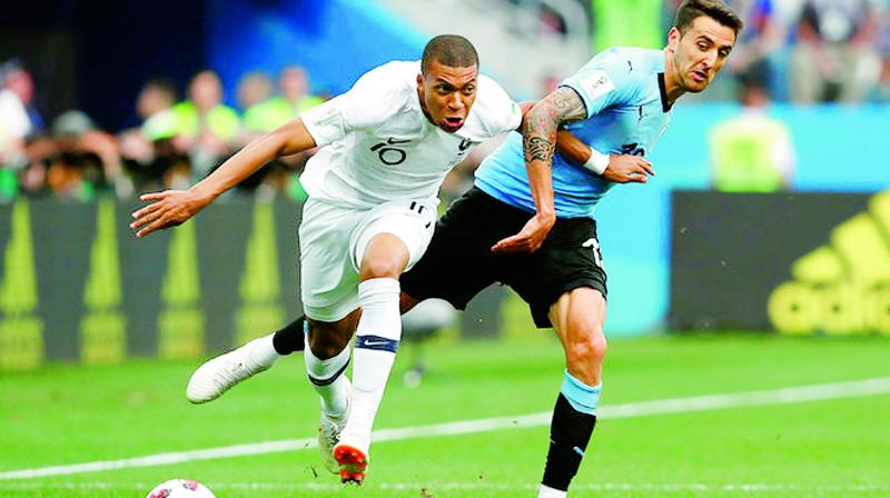 France’s Kylian Mbappe and Uruguay’s Matias Vecino during the quater-final match between the two teams. France’s Kylian Mbappe and Uruguay’s Matias Vecino during the quater-final match between the two teams.