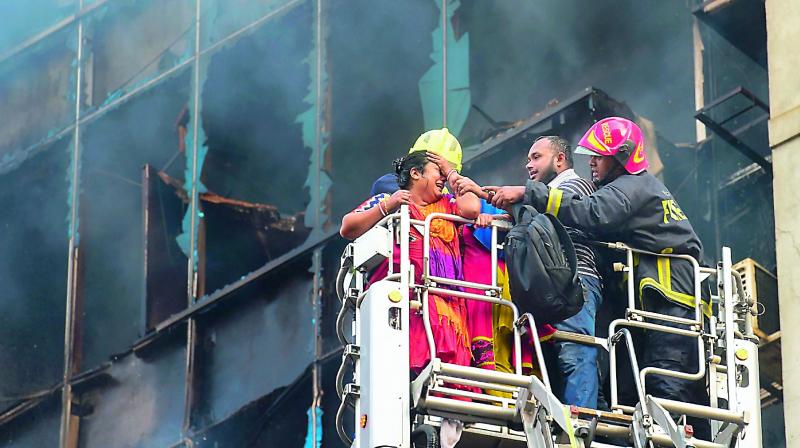 A Bangladeshi survivor reacts after being rescued by firefighters from a burning office building in Dhaka on Thursday. A huge fire tore through a Dhaka office block killing at least seven people with many others feared trapped in the latest major inferno to hit the Bangladesh capital. –AFP A Bangladeshi survivor reacts after being rescued by firefighters from a burning office building in Dhaka on Thursday. A huge fire tore through a Dhaka office block killing at least seven people with many others feared trapped in the latest major inferno to hit the Bangladesh capital. –AFP