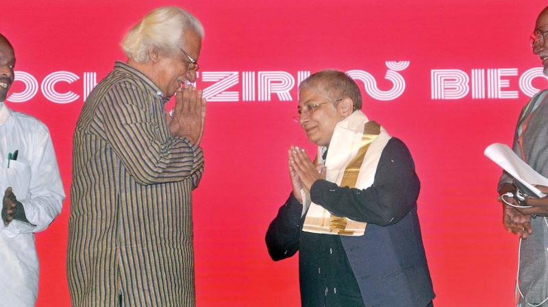 Filmmaker Adoor Gopalakrishnan greets curator Anita Dube after honouring her with a ponnada (golden-laced shawl) at the closing ceremony of 4th edition of Kochi – Muziris Biennale in the presence of Kochi Biennale Foundation president Bose Krishnamachari, in Kochi on Thursday. (Photo: Sunoj ninan mathew ) Filmmaker Adoor Gopalakrishnan greets curator Anita Dube after honouring her with a ponnada (golden-laced shawl) at the closing ceremony of 4th edition of Kochi – Muziris Biennale in the presence of Kochi Biennale Foundation president Bose Krishnamachari, in Kochi on Thursday. (Photo: Sunoj ninan mathew )