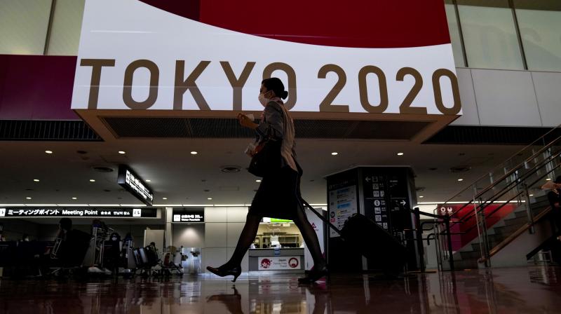 A flight attendant walks by a large display of Tokyo 2020 Olympics at Narita International Airport Thursday. (Photo: AP) A flight attendant walks by a large display of Tokyo 2020 Olympics at Narita International Airport Thursday. (Photo: AP)