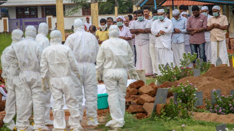 Relatives and hospital officals wear safety masks as they perform the last rites of V Moosa (61), a 'Nipah' virus victim, at Kannam Parambu graveyard, in Kozhikode, on Thursday. (Photo: PTI) Relatives and hospital officals wear safety masks as they perform the last rites of V Moosa (61), a 'Nipah' virus victim, at Kannam Parambu graveyard, in Kozhikode, on Thursday. (Photo: PTI)