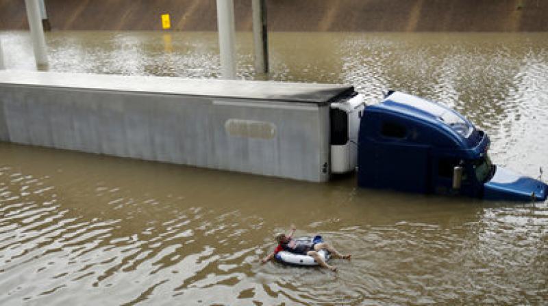 After helping the driver of the submerged truck get to safety, a man floats on the freeway flooded by Tropical Storm Harvey on Sunday, near downtown Houston. (Photo: AP) After helping the driver of the submerged truck get to safety, a man floats on the freeway flooded by Tropical Storm Harvey on Sunday, near downtown Houston. (Photo: AP)