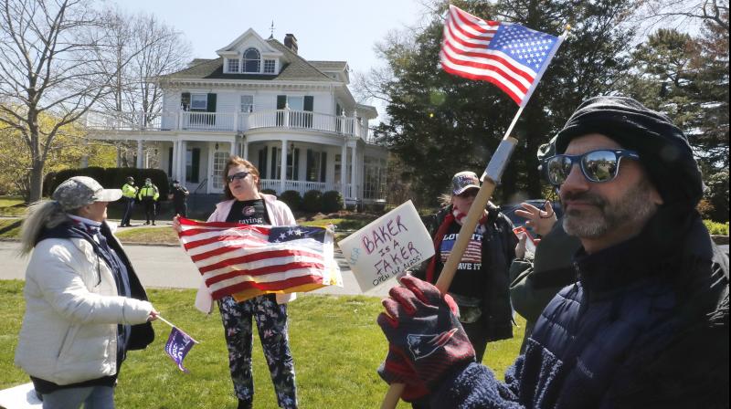 Protesters calling for businesses closed by state order due to the COVID-19 virus outbreak gather outside the home of Massachusetts Gov. Charlie Baker in Swampscott, Massachusetts. AP Photo