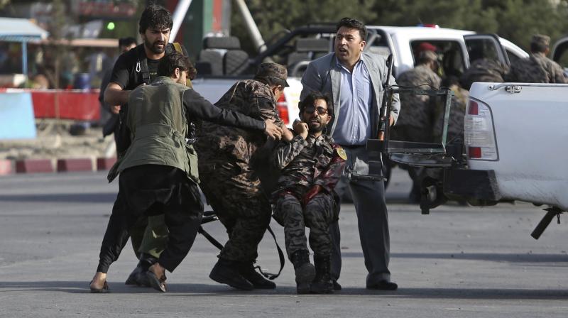 Afghan security personnel carry an injured comrade after an attack near the Kabul International Airport, in Kabul, Afghanistan, Sunday. (Photo: AP) Afghan security personnel carry an injured comrade after an attack near the Kabul International Airport, in Kabul, Afghanistan, Sunday. (Photo: AP)