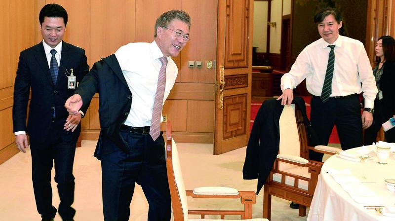 South Korean President Moon Jae-in takes off his jacket at the presidential Blue House in Seoul, South Korea on Thursday. South Korean internet users have shared photos of Moon waving off a presidential employee and taking off his own jacket at a luncheon, projecting an image that he’s a down-to-earth President. (Photo:AP) South Korean President Moon Jae-in takes off his jacket at the presidential Blue House in Seoul, South Korea on Thursday. South Korean internet users have shared photos of Moon waving off a presidential employee and taking off his own jacket at a luncheon, projecting an image that he’s a down-to-earth President. (Photo:AP)
