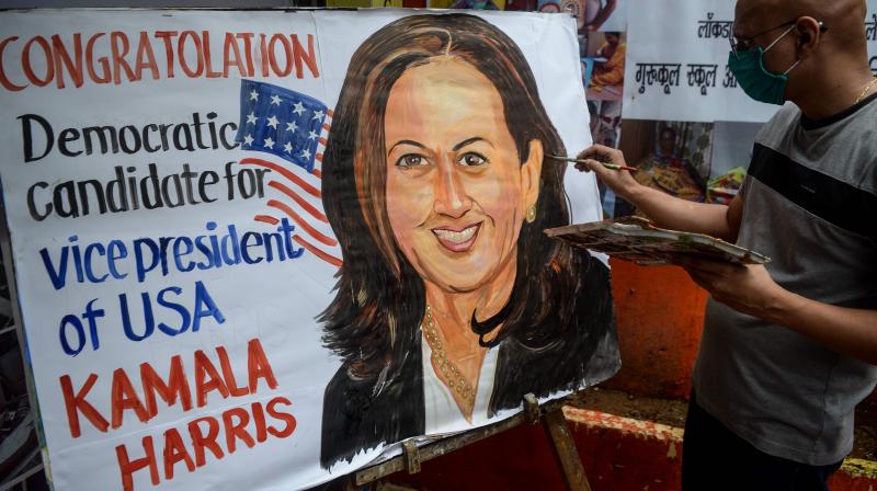 An art enthusiast paints on a canvas the face of presumptive US Democratic Vice President nominee Kamala Harris outside a drawing school in Mumbai. (AFP)
