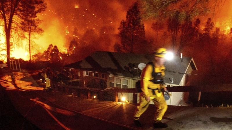 Firefighters protect a home in the Berryessa Estates neighborhood of unincorporated Napa County, California, as the LNU Lightning Complex fires burn. (AP)