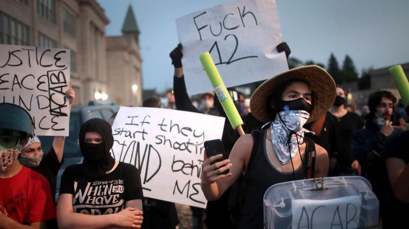 Demonstrators protest near the Kenosha County Courthouse during a third night of unrest. (AFP) Demonstrators protest near the Kenosha County Courthouse during a third night of unrest. (AFP)
