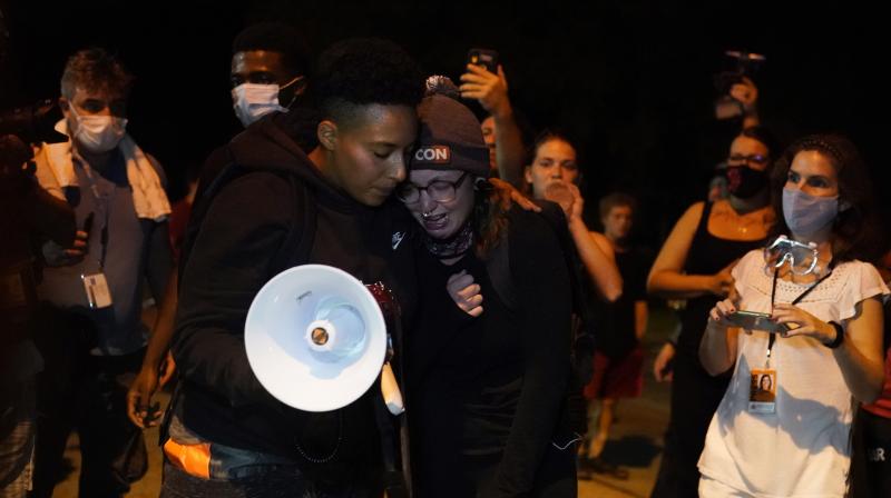 A person, front right, is consoled in Kenosha, as she talks about one of the two people who were fatally shot Tuesday night, whom she described as the love of her life, near the scene of Tuesdays shooting. (AP)