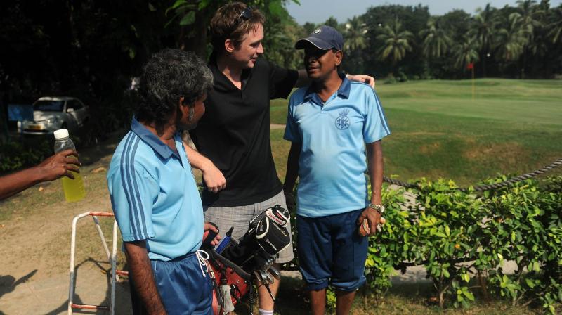 File photo of a golfer interacts with caddies before teeing off in Mumbai. AFP Photo File photo of a golfer interacts with caddies before teeing off in Mumbai. AFP Photo