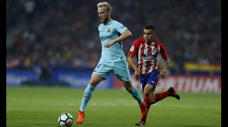 Barcelonas Ivan Rakitic (L) runs with the ball ahead of Atletico Madrids Angel Correa during a Spanish La Liga match. AP Photo/Francisco Seco)