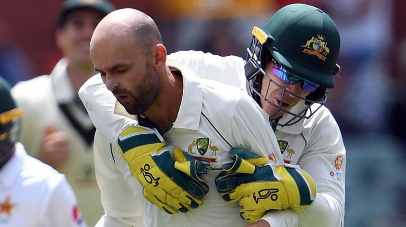 Nathan Lyon celebrates his wicket with captain and wicketTim Paine (R) and Marnus Labuschagne during the day four of the second cricket Test match between Australia and Pakistan in Adelaide on December 2, 2019. (Photo by William WEST / AFP) /