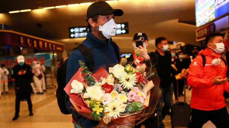 Wuhan Zall football team coach Jose Gonzalez (C) arriving with his players at the railway station in Wuhan, in Chinas central Hubei province, on Friday. AFP Photo