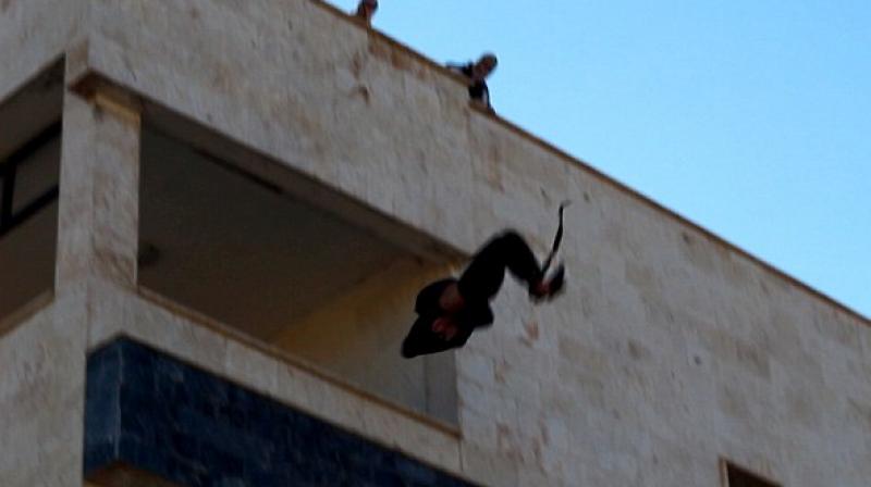 The militants then pushed the prisoner off the building in front of a baying crowd gathered below the building. (Photo: Twitter) The militants then pushed the prisoner off the building in front of a baying crowd gathered below the building. (Photo: Twitter)