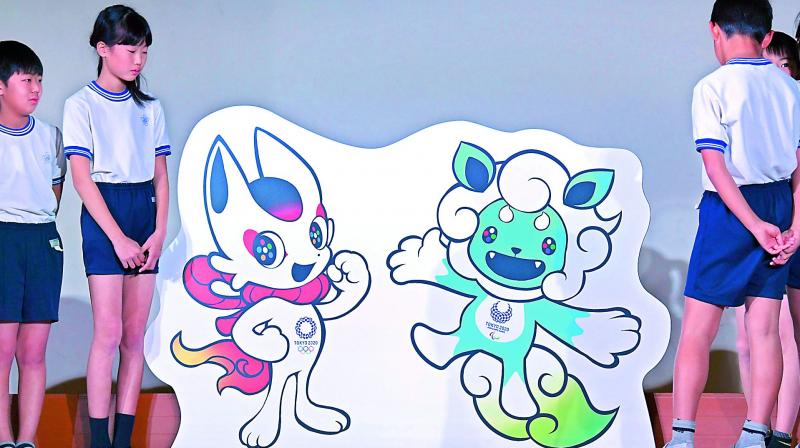 Schoolchildren pose beside a pair of official Tokyo 2020 Olympic Games mascots, one of three shortlisted pairs to be unveiled in Tokyo. (Photo: AFP0 Schoolchildren pose beside a pair of official Tokyo 2020 Olympic Games mascots, one of three shortlisted pairs to be unveiled in Tokyo. (Photo: AFP0