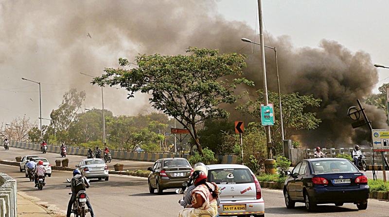 Huge cloud of smoke covering the Ring Road near Sumanahalli Flyover, causing problems to the residents and the motorists due to burning of garbage, in Bengaluru on Sunday. (Photo:DC) Huge cloud of smoke covering the Ring Road near Sumanahalli Flyover, causing problems to the residents and the motorists due to burning of garbage, in Bengaluru on Sunday. (Photo:DC)