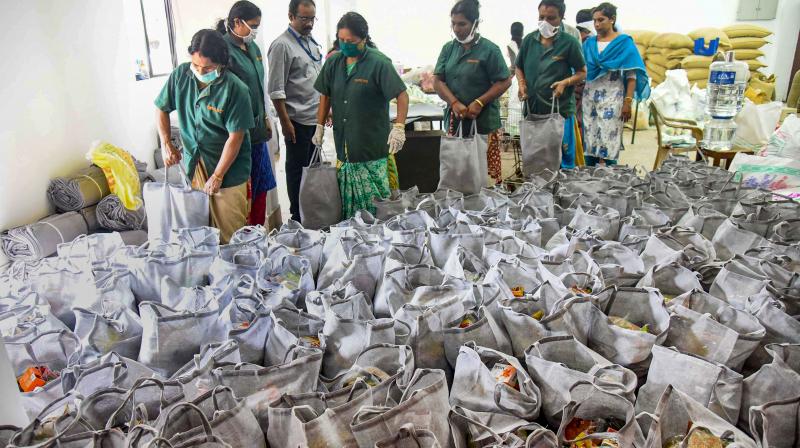 Workers arrange sacks containing essential supplies provided by the government during the current nationwide lockdown. (PTI) Workers arrange sacks containing essential supplies provided by the government during the current nationwide lockdown. (PTI)
