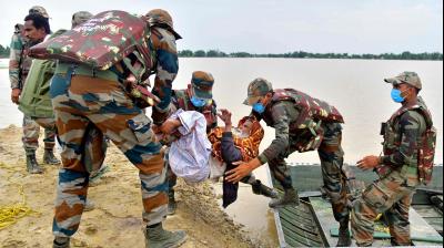 Army soldiers evacuate a flood-affected villager after heavy rains in Hojai district of Assam on May 19, 2022.  (Biju BORO / AFP)