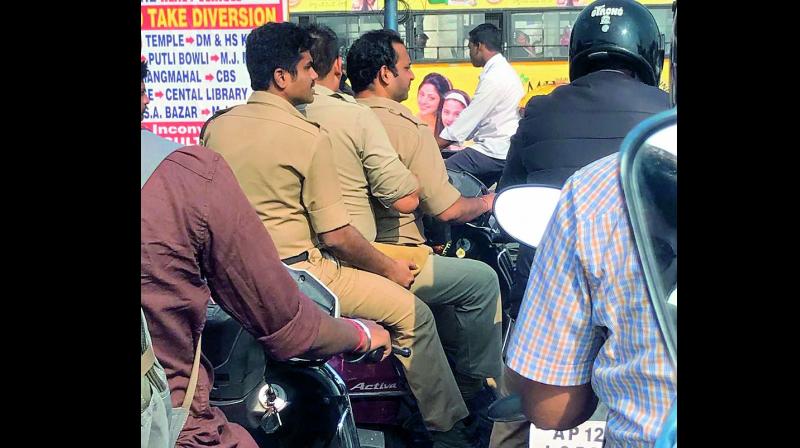 Cops were seen triple riding without wearing helmet on Monday. (Photo: DC) Cops were seen triple riding without wearing helmet on Monday. (Photo: DC)