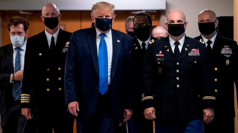 US President Donald Trump wears a mask as he visits Walter Reed National Military Medical Center in Bethesda, Maryland (AFP)