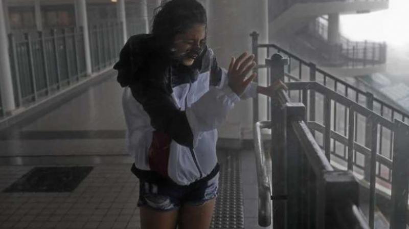 A girl stands against strong wind caused by Typhoon Mangkhut at a pier on the waterfront of Victoria Habour Hong Kong. (Photo: AP) A girl stands against strong wind caused by Typhoon Mangkhut at a pier on the waterfront of Victoria Habour Hong Kong. (Photo: AP)