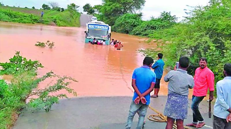 A bus carrying Kaleshwaram visitors was struck in flood water of the Chandruvalli rivulet in old Karimnagar district on Sunday. A bus carrying Kaleshwaram visitors was struck in flood water of the Chandruvalli rivulet in old Karimnagar district on Sunday.