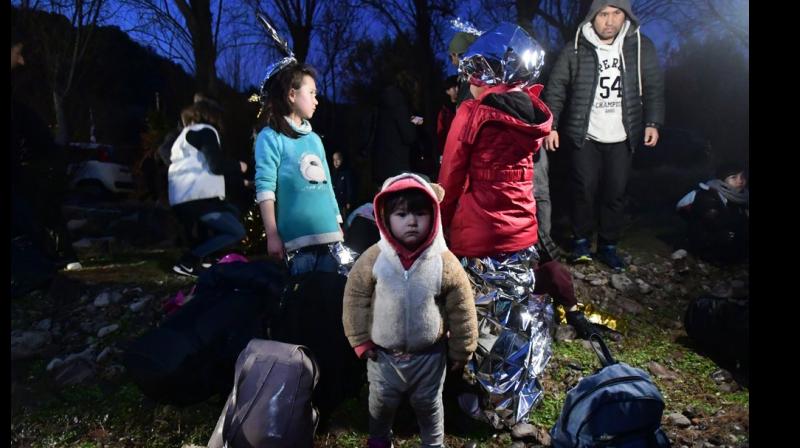 Migrants arrive at the village of Skala Sikaminias, on the Greek island of Lesbos, after crossing on a dinghy the Aegean sea from Turkey, Sunday (AP Photo)
