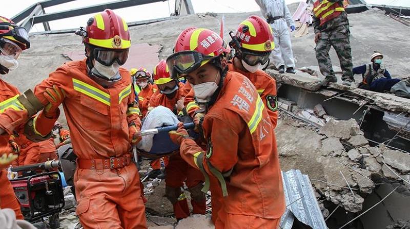 A man is rescued from the rubble of a collapsed hotel in Quanzhou where 71 people were held under observation for coronavirus [AFP]