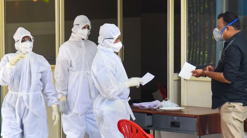 Medical staff members wear masks and protective suits to mitigate the spread of coronavirus, outside the special isolation ward of District Hospital Aluva in Kochi (PTI)