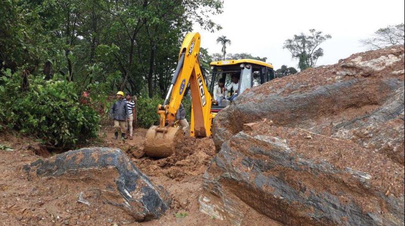 An earth-mover clears the sludge from a road in the flood-hit in Mangaluru (Image: DC) An earth-mover clears the sludge from a road in the flood-hit in Mangaluru (Image: DC)