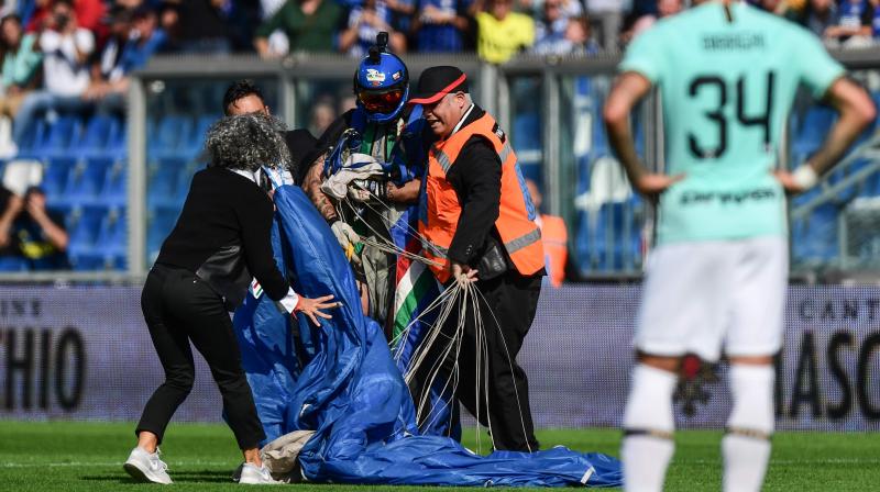 The parachutist was quickly evacuated by security agents at the stadium in Emilia-Romagna. (Photo :AFP) The parachutist was quickly evacuated by security agents at the stadium in Emilia-Romagna. (Photo :AFP)