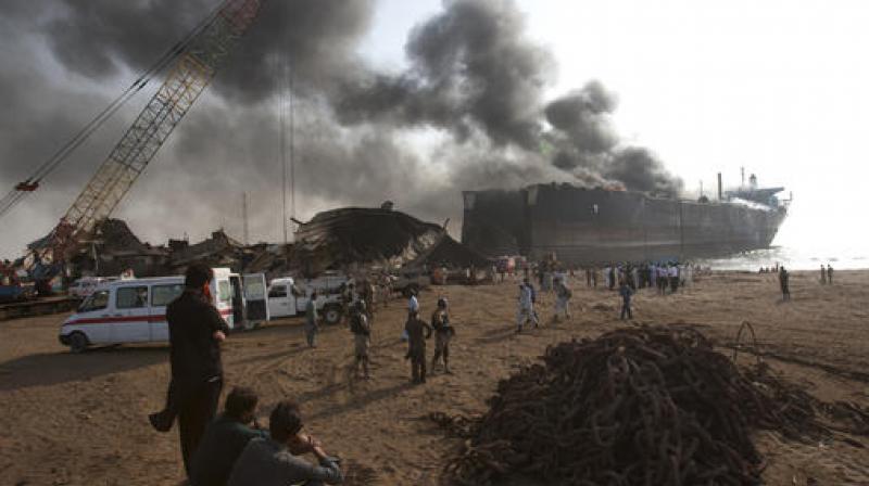 People look at a ship on fire following an explosion, in the coastal town of Gadani, Pakistan. (Photo: AP) People look at a ship on fire following an explosion, in the coastal town of Gadani, Pakistan. (Photo: AP)