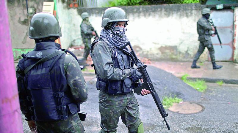 Soldiers patrol a street during a surprise operation at the Vila Alianca slum in Rio de Janeiro, Brazil, on Friday. (Photo: AP) Soldiers patrol a street during a surprise operation at the Vila Alianca slum in Rio de Janeiro, Brazil, on Friday. (Photo: AP)