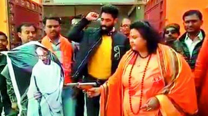 A woman leader of Hindu Mahasabha firing at an effigy of Mahatma Gandhi with an air pistol on Wednesday. A woman leader of Hindu Mahasabha firing at an effigy of Mahatma Gandhi with an air pistol on Wednesday.