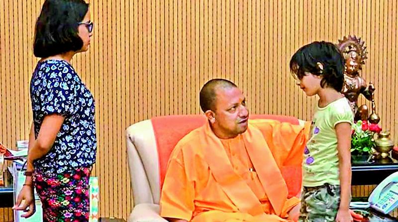 UP CM Yogi Adityanath interacts with Tiwari’s family. —PTI UP CM Yogi Adityanath interacts with Tiwari’s family. —PTI