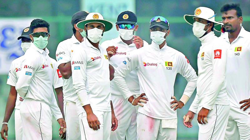 Sri Lankan players wear masks on the field, complaining that air quality had deteriorated during the second day of their third Test against India in New Delhi on Sunday. Two bowlers walked off, and India declared their innings after Lanka complained they were not in a position to have 11 players on the field. (Photo: PTI) Sri Lankan players wear masks on the field, complaining that air quality had deteriorated during the second day of their third Test against India in New Delhi on Sunday. Two bowlers walked off, and India declared their innings after Lanka complained they were not in a position to have 11 players on the field. (Photo: PTI)