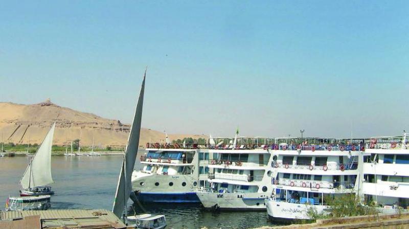 Traditional feluccas and modern cruise ships on the Nile Traditional feluccas and modern cruise ships on the Nile
