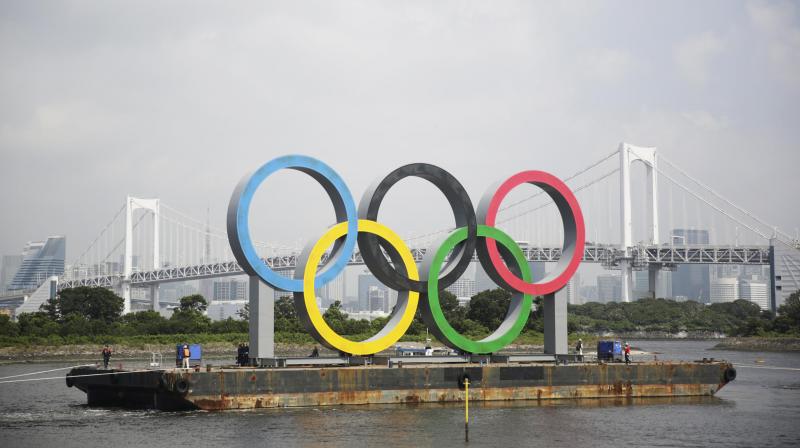 In this Aug. 6, 2020, file photo, the Olympic rings for the Olympic and Paralympic Games Tokyo 2020 pass by on a barge by tugboats off the Odaiba Marine Park in Tokyo. (Photo: AP)