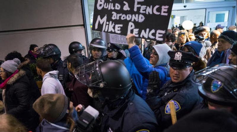 Protesters are surrounded by police officers and travelers as they pass through an exit of Terminal 4 at John F. Kennedy International Airport in New York. (Photo: AP) Protesters are surrounded by police officers and travelers as they pass through an exit of Terminal 4 at John F. Kennedy International Airport in New York. (Photo: AP)
