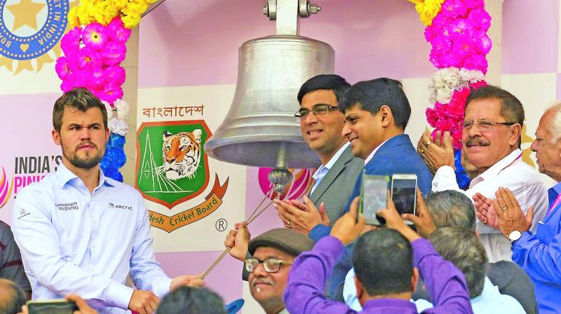 Current world chess champion Magnus Carlsen (left) and five-time world chess champion Viswanathan Anand ring the bell on Day Two at the Eden Gardens in Kolkata on Saturday. (Photo: BCCI)