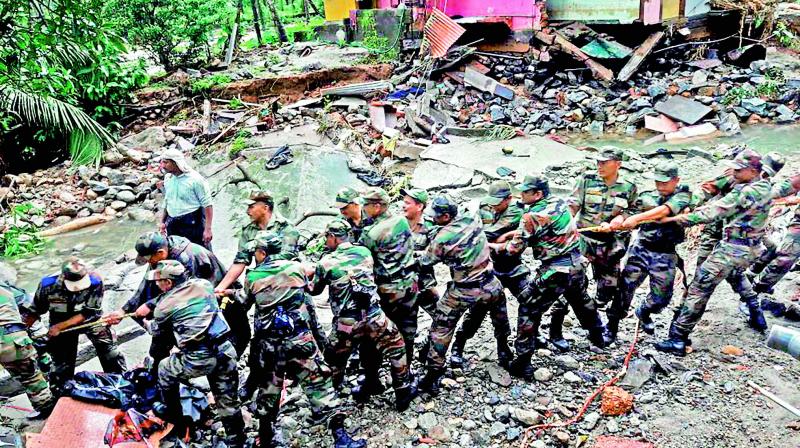 Soldiers clear the debris off a road in a flooded affected area at Wayanad. Soldiers clear the debris off a road in a flooded affected area at Wayanad.