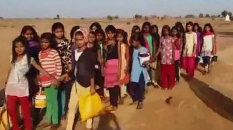 Accompanied by school teacher and other staff workers the girls of Madhya Pradesh village walk 4 km for their basic need. (Photo: ANI | Twitter) Accompanied by school teacher and other staff workers the girls of Madhya Pradesh village walk 4 km for their basic need. (Photo: ANI | Twitter)