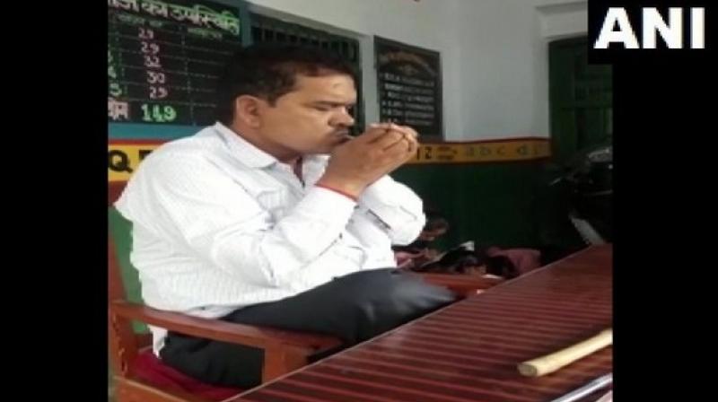 In the video, the teacher was seen lighting and smoking a beedi in front of primary students inside the classroom. (Photo: ANI) In the video, the teacher was seen lighting and smoking a beedi in front of primary students inside the classroom. (Photo: ANI)