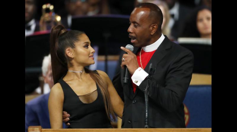 After her performance, Ariana Grande was congratulated by Bishop Charles H Ellis III, who wrapped his arm around her, his hand high above her waist and his fingers pressed against her chest. (Photo: AP) After her performance, Ariana Grande was congratulated by Bishop Charles H Ellis III, who wrapped his arm around her, his hand high above her waist and his fingers pressed against her chest. (Photo: AP)