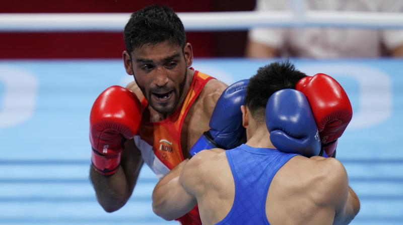 Indias Ashish Kumar, left, exchanges punches with Chinas Tuoheta Erbieke during their mens middleweight 75-kg boxing match at the Summer Olympics in Tokyo on Monday. (Photo: AP)