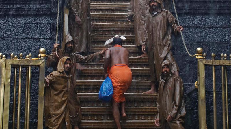 A lone devotee ascends the 18 holy steps on way to sanctum sanctorum amidst heavy rain in Sabarimala. (By Agreement) A lone devotee ascends the 18 holy steps on way to sanctum sanctorum amidst heavy rain in Sabarimala. (By Agreement)