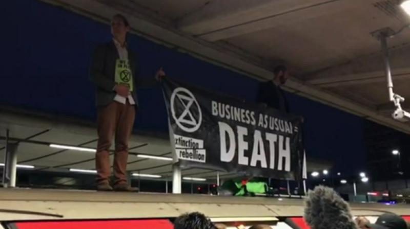 Climate activists took to roofs of trains in London. (Photo: AP) Climate activists took to roofs of trains in London. (Photo: AP)