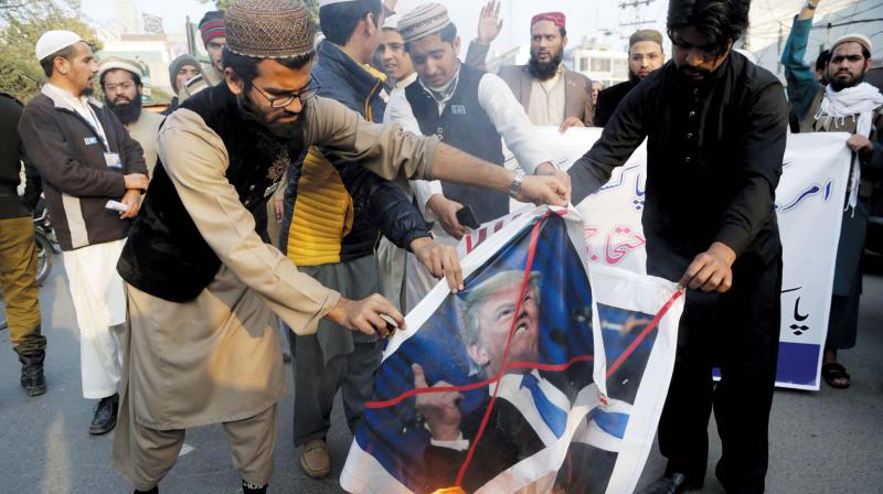 Pakistani protesters burn posters of US President Donald Trump in Lahore. Pakistani protesters burn posters of US President Donald Trump in Lahore.