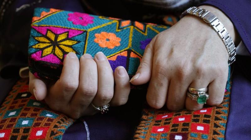 A Massachusetts resident identifying herself only as \Safi,\ who asked that her last name not be used for fear of retribution against her relatives in Afghanistan, holds a purse with traditional Afghan patterns, during an interview with The Associated Press. (AP/Steven Senne)