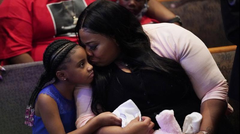 Roxie Washington holds Gianna Floyd, the daughter of George Floyd as they attend the funeral service for George Floyd at The Fountain of Praise church in Houston. AP photo